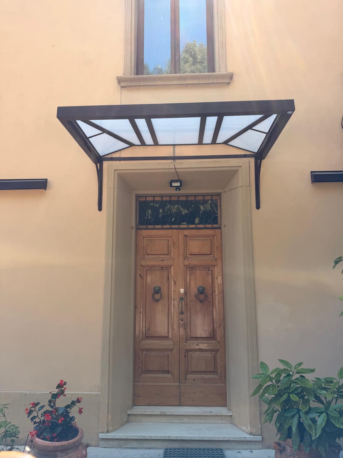 Pensilina moderna in ferro e vetro sopra ingresso